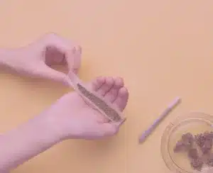 Image of a man rolling cannabis pre-roll